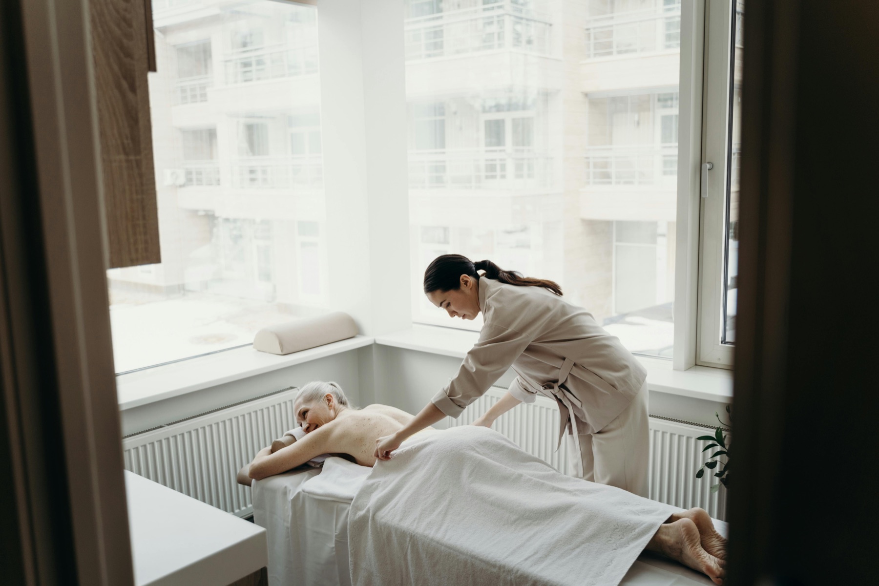 Massage therapist providing attentive bodywork in a serene spa room